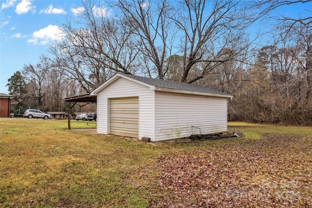 garage with a carport and a yard