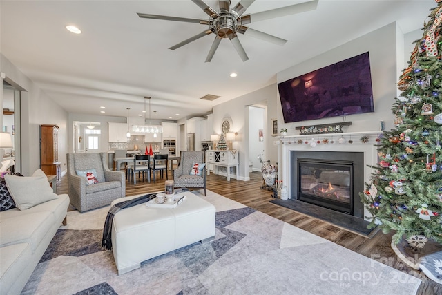 living room with ceiling fan and hardwood / wood-style flooring