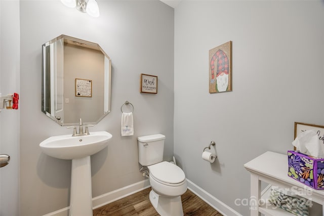 bathroom with hardwood / wood-style floors and toilet