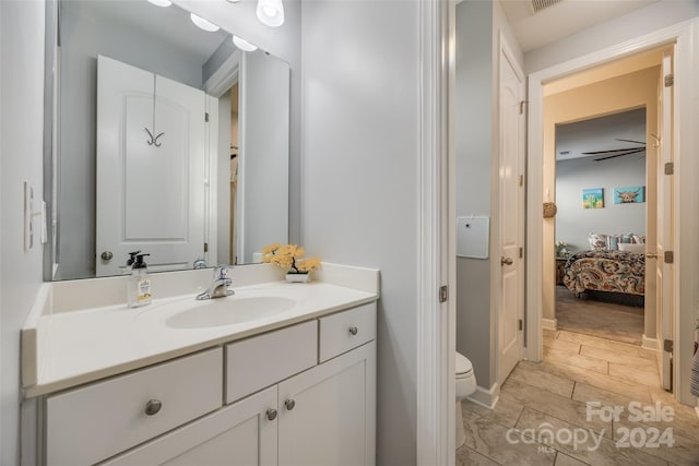 bathroom featuring vanity, toilet, and ceiling fan