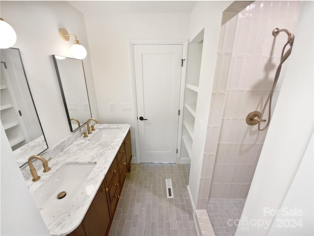 bathroom featuring tiled shower and vanity