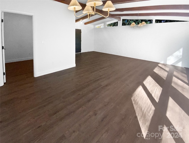 spare room featuring a chandelier, lofted ceiling with beams, and dark hardwood / wood-style floors