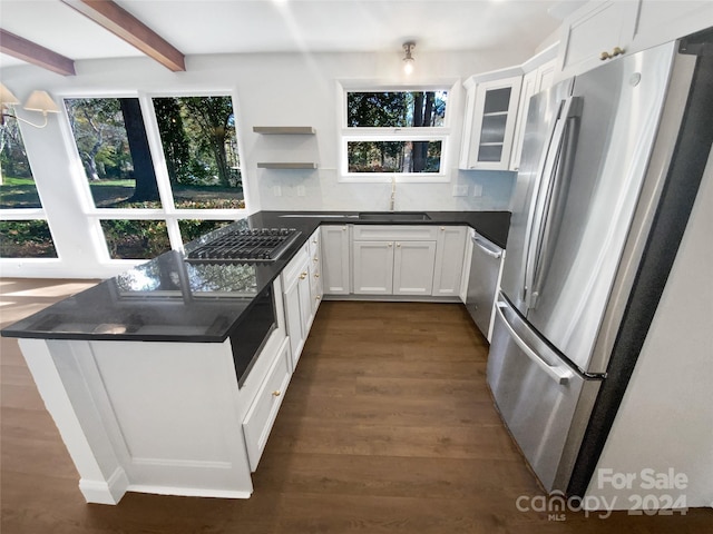 kitchen featuring white cabinets, sink, dark hardwood / wood-style floors, appliances with stainless steel finishes, and beamed ceiling