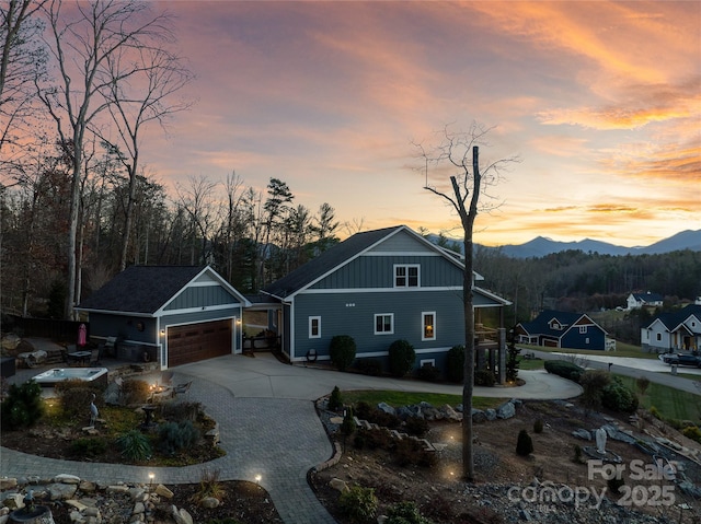 view of front of property with an outbuilding, decorative driveway, board and batten siding, and a mountain view