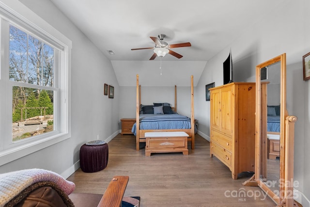 bedroom featuring light wood-type flooring, visible vents, and lofted ceiling