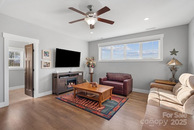 living area with baseboards, visible vents, and light wood finished floors