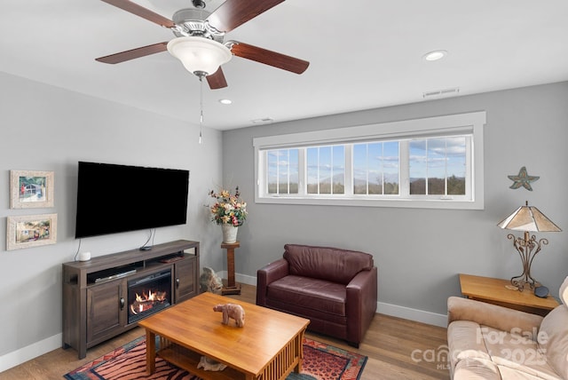 living room with baseboards, visible vents, and light wood-style floors