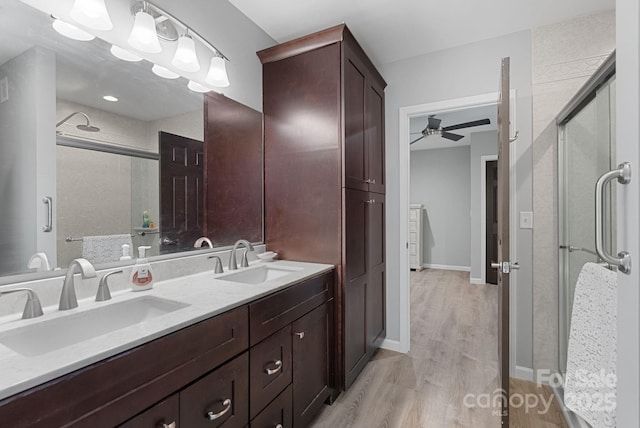 bathroom with a sink, a shower stall, and wood finished floors