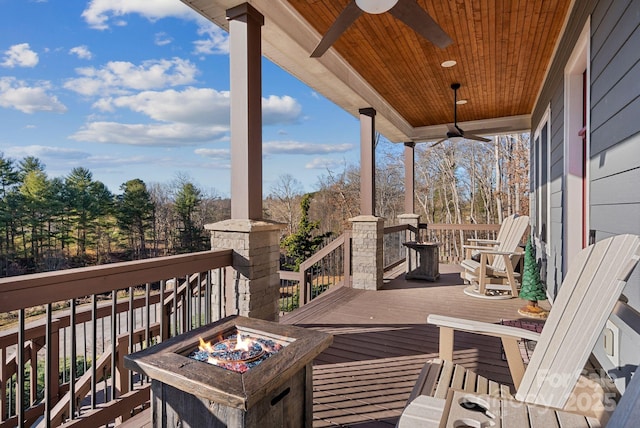 wooden deck featuring an outdoor fire pit and a ceiling fan