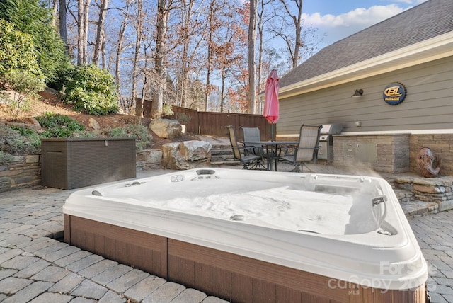 view of patio / terrace featuring hot tub deck surround, fence, and outdoor dining space