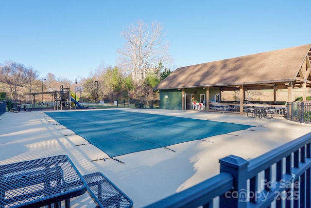 pool featuring playground community, a patio area, and fence