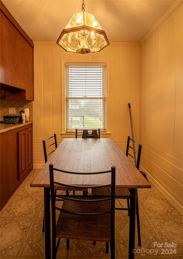 dining space with ornamental molding and a chandelier