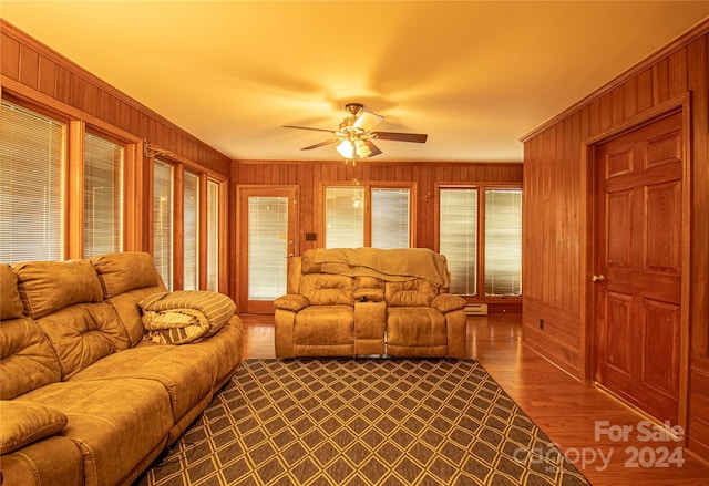 654 Meadowlark Dr, Winston Salem, NC 27106 - living room featuring healthy amount of natural light, wood walls, a ceiling fan, and dark wood-type flooring