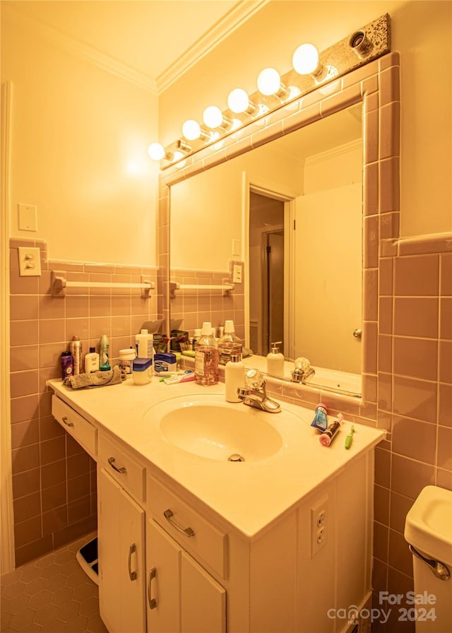 bathroom with ornamental molding, vanity, tile walls, tile patterned flooring, and toilet