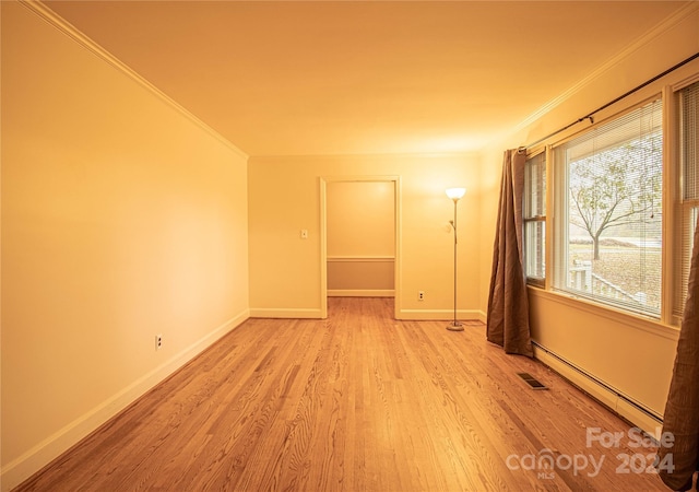 654 Meadowlark Dr, Winston Salem, NC 27106 - spare room with baseboard heating, ornamental molding, and light wood-style flooring