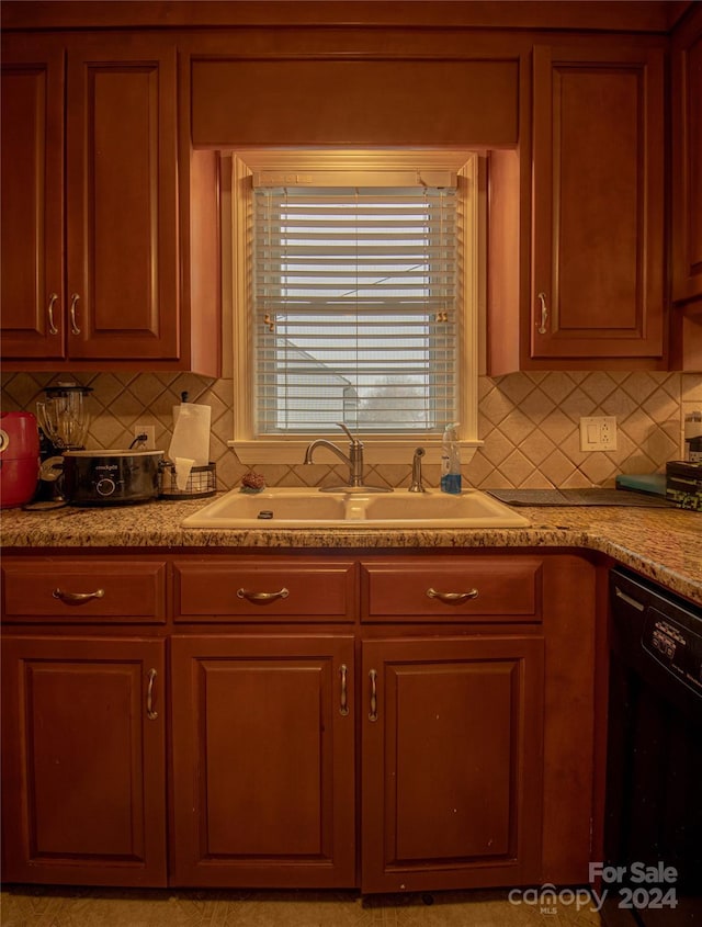 kitchen featuring dishwasher, backsplash, and sink