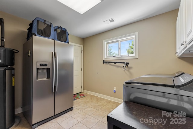 kitchen with visible vents, baseboards, stainless steel fridge with ice dispenser, light tile patterned floors, and white cabinetry