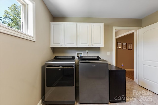 clothes washing area with baseboards, cabinet space, independent washer and dryer, and light tile patterned flooring