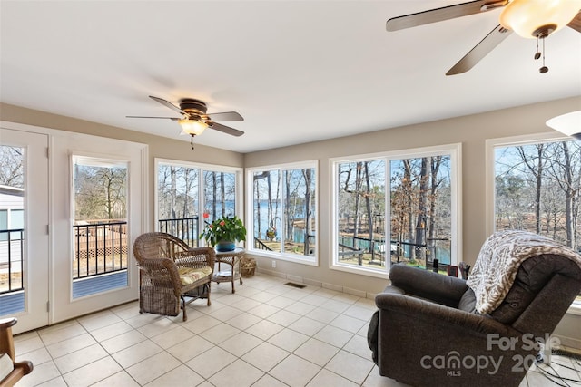 sunroom / solarium with a wealth of natural light, visible vents, and a ceiling fan