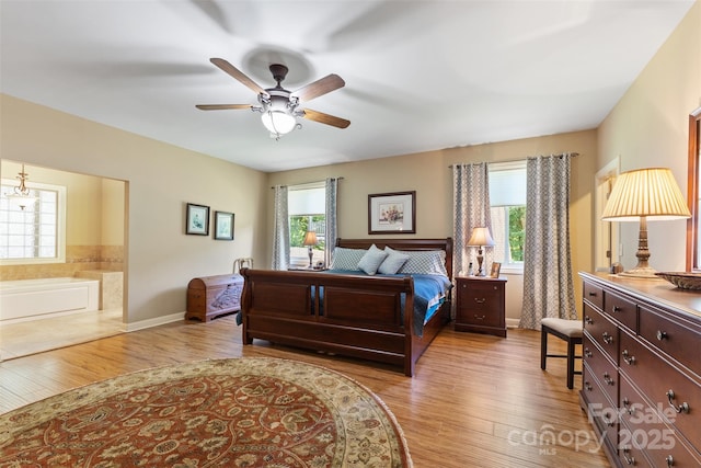 bedroom with connected bathroom, wood finished floors, baseboards, and ceiling fan