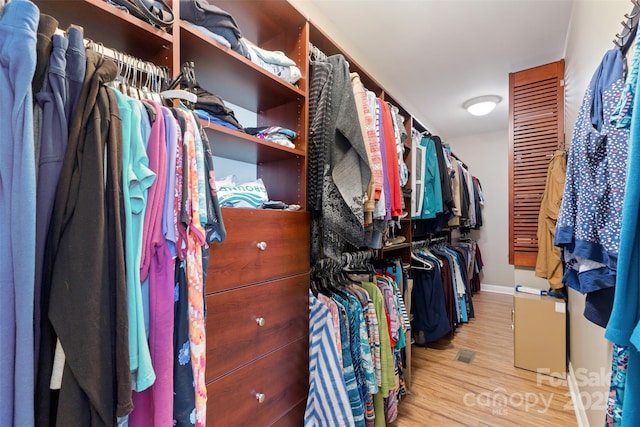 walk in closet with wood finished floors