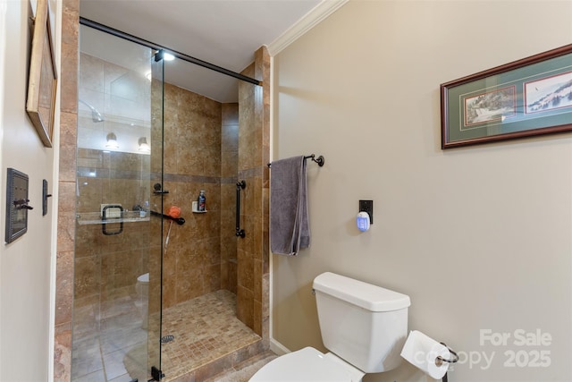 bathroom featuring a shower stall, toilet, and crown molding