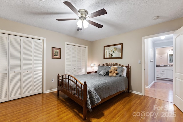 bedroom with a textured ceiling, light wood-type flooring, and baseboards