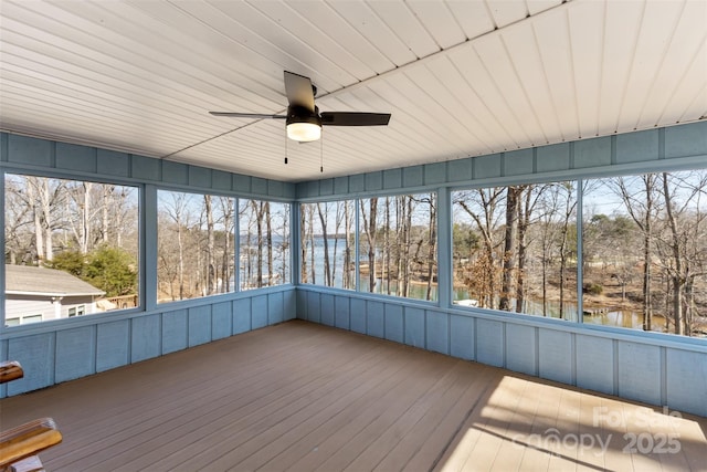 unfurnished sunroom with a water view and ceiling fan