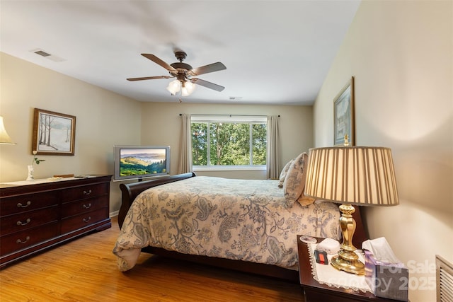 bedroom with light wood-type flooring, visible vents, and ceiling fan