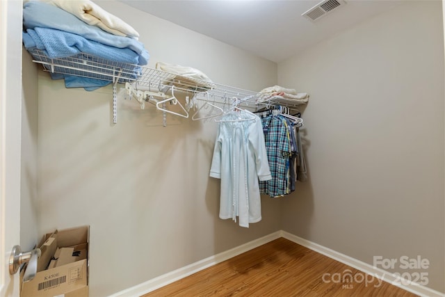 spacious closet featuring visible vents and wood finished floors