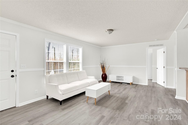 unfurnished living room with light hardwood / wood-style floors, a textured ceiling, and ornamental molding