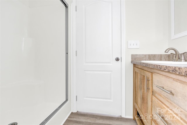 bathroom with vanity, wood-type flooring, and walk in shower