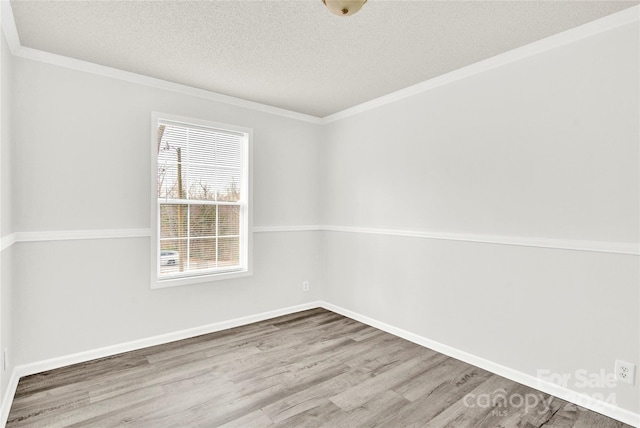 spare room featuring ornamental molding, a textured ceiling, and hardwood / wood-style flooring