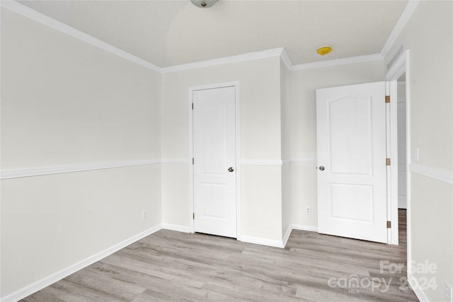 unfurnished bedroom with light hardwood / wood-style floors and ornamental molding