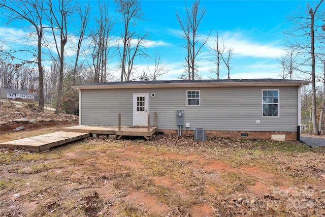 rear view of house featuring a wooden deck and cooling unit