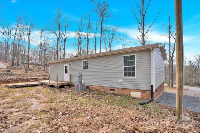 back of property with central AC and a wooden deck