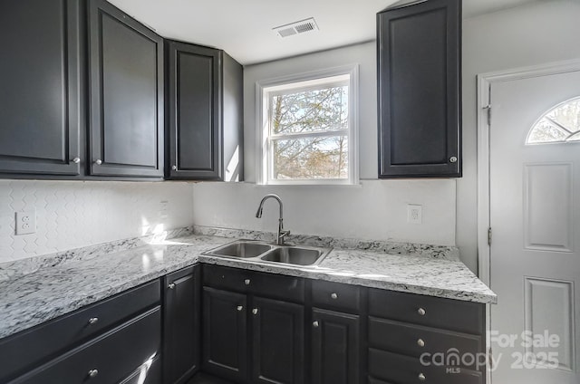 kitchen featuring light stone countertops and sink