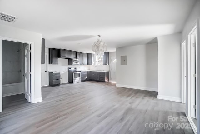 kitchen with wood-type flooring, stainless steel appliances, gray cabinetry, and sink