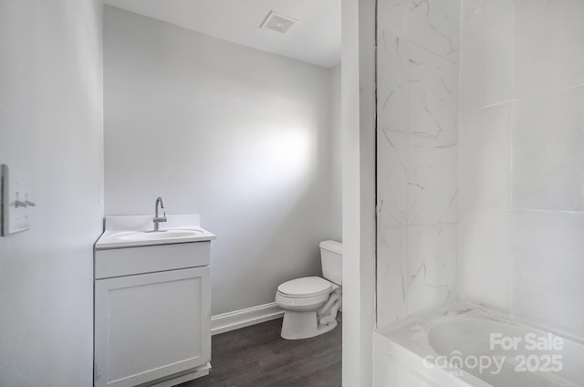 full bathroom with washtub / shower combination, vanity, wood-type flooring, and toilet