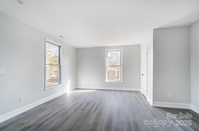 unfurnished room with wood-type flooring and plenty of natural light