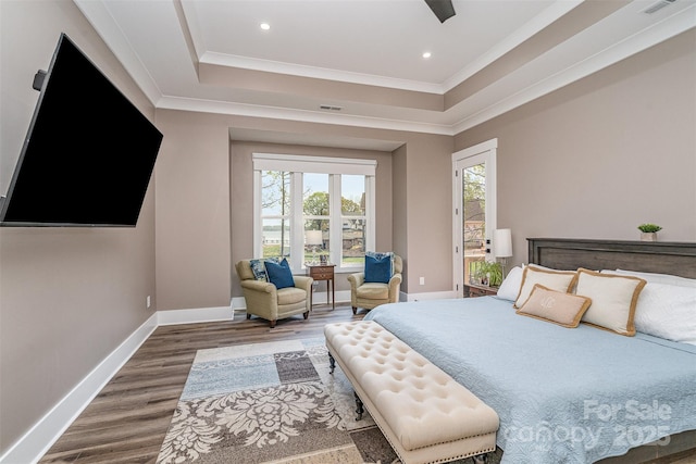 bedroom with crown molding, dark wood-type flooring, a raised ceiling, and access to outside