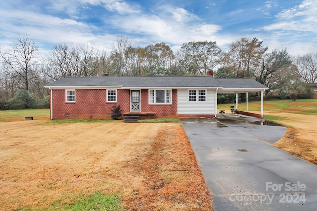 ranch-style home with a carport and a front lawn