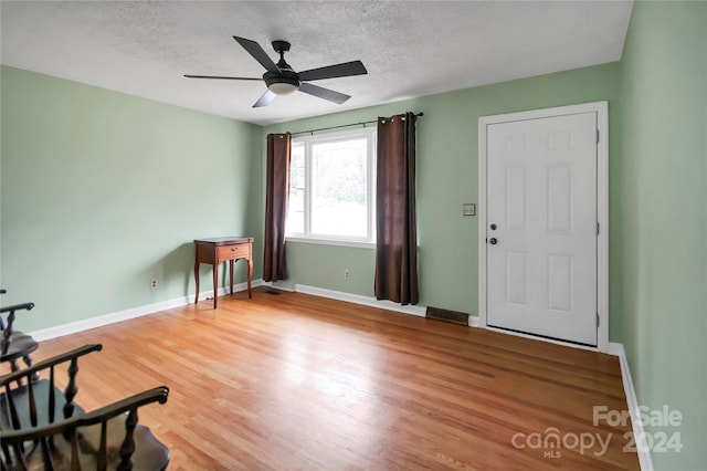 interior space with ceiling fan, hardwood / wood-style floors, and a textured ceiling