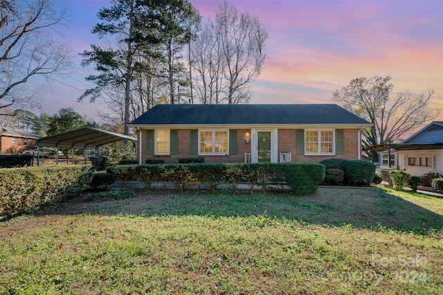 view of front of property with a lawn and a carport