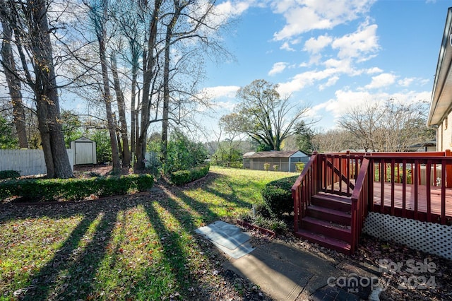 view of yard featuring a wooden deck and a storage unit