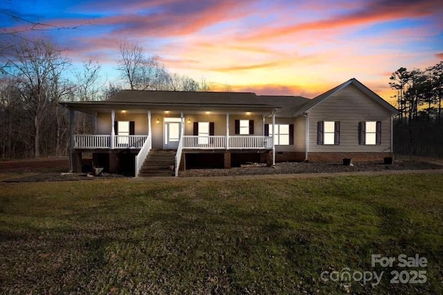 ranch-style home featuring a yard and covered porch