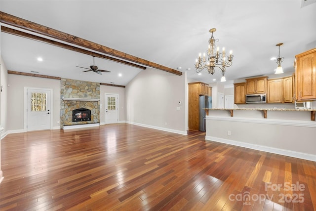 unfurnished living room featuring dark hardwood / wood-style flooring, a fireplace, ceiling fan with notable chandelier, and vaulted ceiling with beams