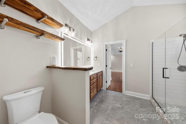 bathroom with ceiling fan, vaulted ceiling, toilet, a shower with door, and vanity