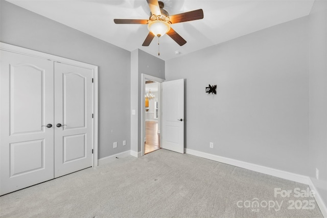 unfurnished bedroom featuring light carpet, a closet, and ceiling fan