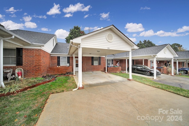 view of front facade featuring a front lawn and a carport